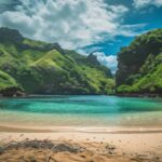 A Fiji beach cove with clear blue waters and a backdrop of lush, green mountains background.