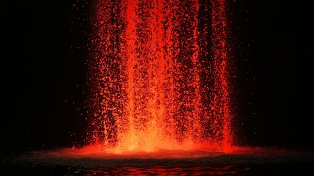 A cascade of red flames pouring down from the top of the frame, illuminating the black background for desktop.