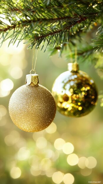 A close up of elegant Christmas ornaments hanging from a lush green tree, with a warm, bokeh background.