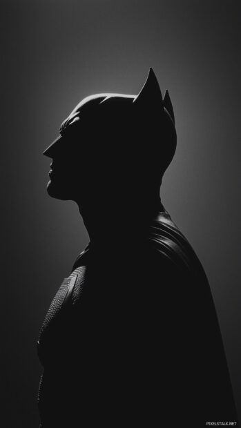 A minimalist silhouette of Batman against a dark background, his cape flowing slightly.