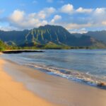 A peaceful morning at Hawaii beach with soft light illuminating the sand and calm waters.