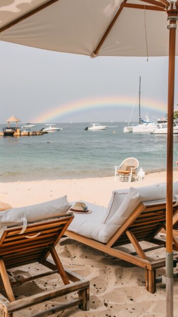 A preppy beach wallpaper with a rainbow over the ocean and nautical decor.