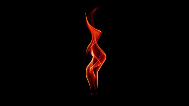 A red flame is burning, the background is black.