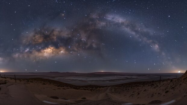 The Milky Way galaxy desktop wallpaper 4K from a dark desert landscape, with stars shining brightly.