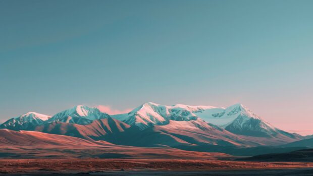 Winter desktop wallpaper 4K with snow capped mountains and a clear sky.