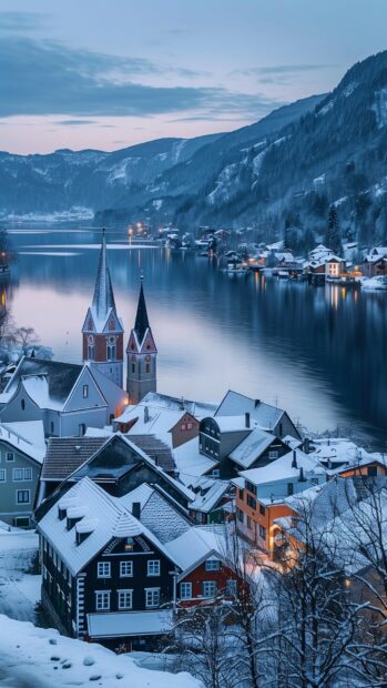 Winter wallpaper for iPhone with a picturesque village nestled in the snow at dusk.