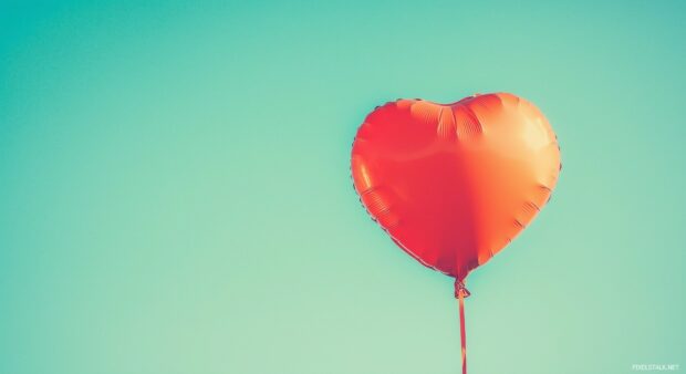 3D Heart shaped balloon floating in a sky blue.