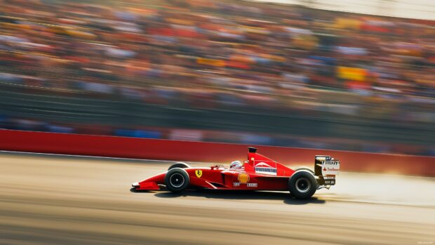 A Formula 1 race car speeding through the final lap of a Grand Prix, with the crowd blurred in the background.