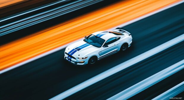 A Shelby Mustang GT350 in racing white with blue stripes, speeding through a racetrack with a blurred background emphasizing its speed.