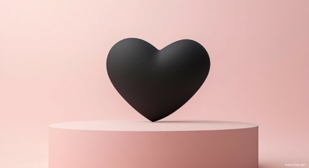 A close up of a matte black heart against a muted pastel background.