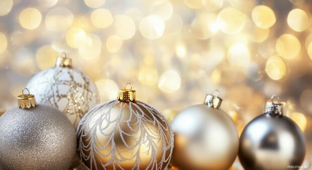 A close up of elegant gold and silver Christmas ornaments with intricate designs, set against a blurred festive background.