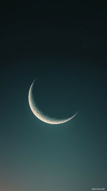 A crescent moon glowing softly in a dark, starless sky.