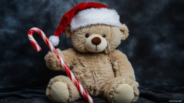 A cute teddy bear wearing a Santa hat and holding a candy cane.