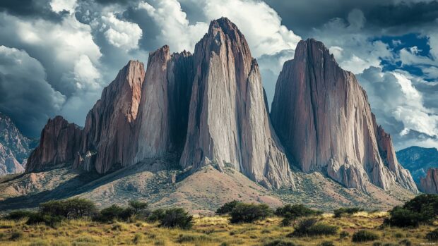 A dramatic mountain vista with sharp ridges and deep shadows under a cloudy sky.