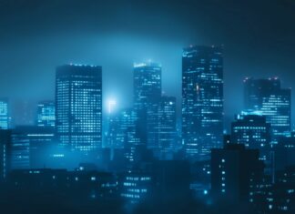 A foggy city night with skyscrapers partially obscured by mist, illuminated by soft glowing lights.