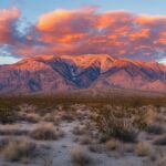 A majestic Mountain range glowing under the fiery hues of a sunset sky.