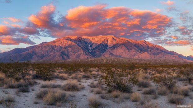 A majestic Mountain range glowing under the fiery hues of a sunset sky.