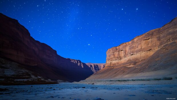 A mysterious mountain range illuminated by faint moonlight, with dark night.