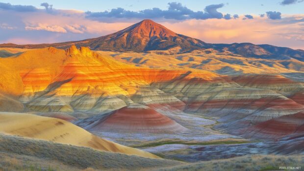 A panoramic view of a Mountain valley bathed in warm sunset light.