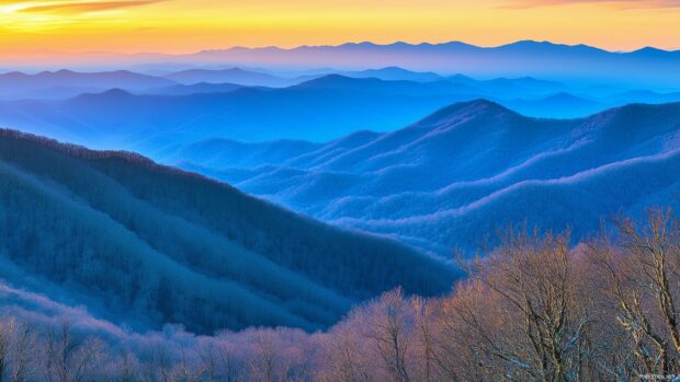 A panoramic view of a Mountain valley bathed in warm sunset light, with shadows stretching across rolling hills.