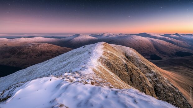 A panoramic view of a snow covered Mountain wallpaper.