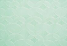 A pastel green wallpaper featuring a subtle, elegant geometric pattern.