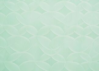 A pastel green wallpaper featuring a subtle, elegant geometric pattern.