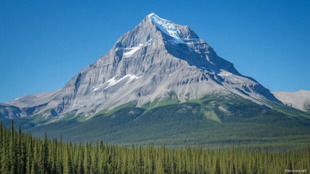 A rugged Rocky Mountain peak under a blue sky.