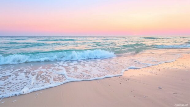 A seascape 1920x1080 Wallpaper HD with gentle waves rolling onto a sandy beach, the horizon blending into a soft pastel sunset.