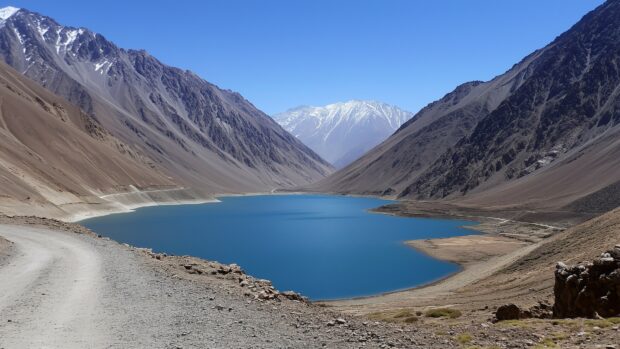 A serene blue Mountain lake surrounded by towering peaks under a crisp, clear sky.