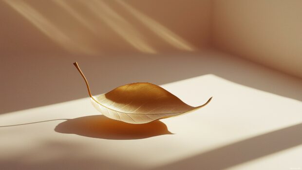 A single golden leaf resting on a soft beige background, minimalist elegance, crisp lines, and subtle shadows.