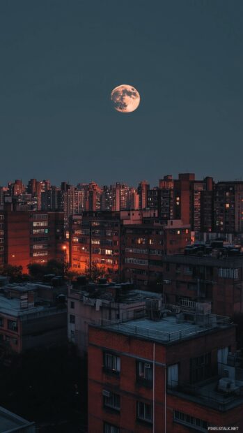 A striking full moon casting its glow over a city skyline.