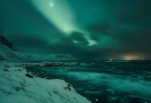 A stunning aurora borealis lighting up the night sky over a snowy landscape.