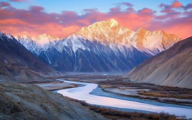 A vast mountain valley landscape surrounded by towering peaks.