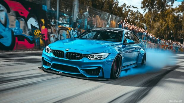 A vibrant blue BMW M3 in mid drift on an urban track, with graffiti covered walls and spectators cheering in the background.