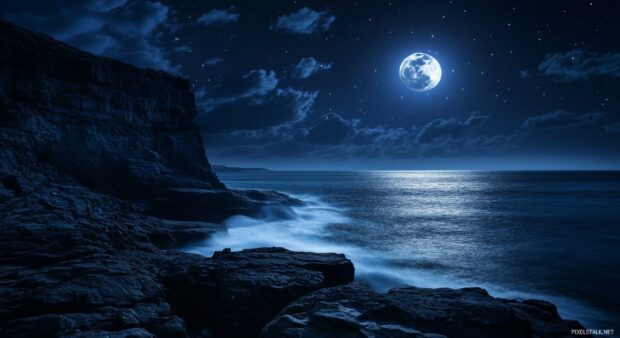 A vivid night sky with a full moon casting its glow over a coastal cliff, with the ocean waves gently illuminated by the moonlight.