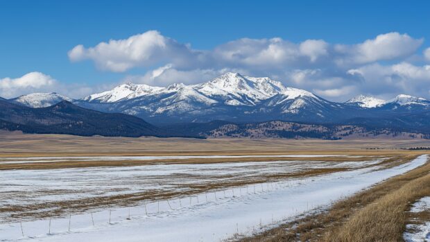 A wide view of a snow Mountain range with an endless stretch of untouched snowfields.