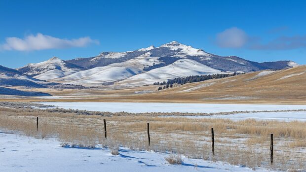 A wide view of a snow mountain range with an endless stretch of untouched snowfields.