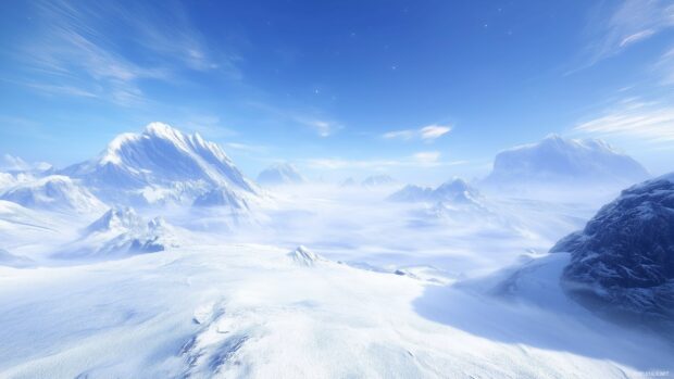 A winter wonderland of mountains covered in fresh snow under a clear blue sky.