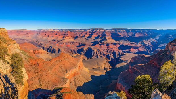 Beautiful Laptop Wallpaper HD with a panoramic view of the Grand Canyon with dramatic shadows and a clear sky.