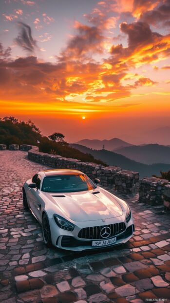 Car parked on a mountain road with a breathtaking sunset.