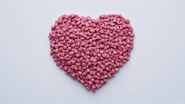 Cluster of small pink hearts forming a larger heart shape on a white background.