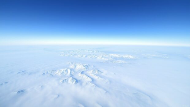 Cool blue mountains stretching into the horizon under a soft pastel sky.