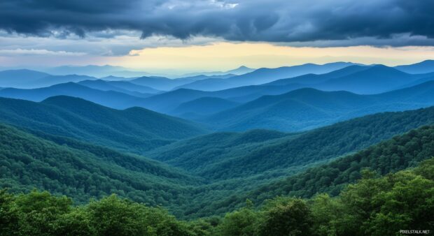 Dark mountains shrouded in mist under a dramatic stormy sky.