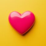 Flat heart valentine in bright pink on a simple yellow background.