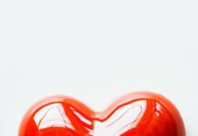 Heart shape in bright red on a simple white background.