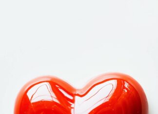 Heart shape in bright red on a simple white background.