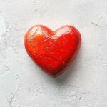 Heart shape in bright red on a simple white background.