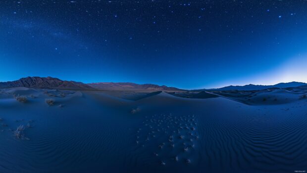 Laptop 4K Wallpaper with majestic desert dunes under a clear night sky filled with stars, a peaceful and minimalist landscape.