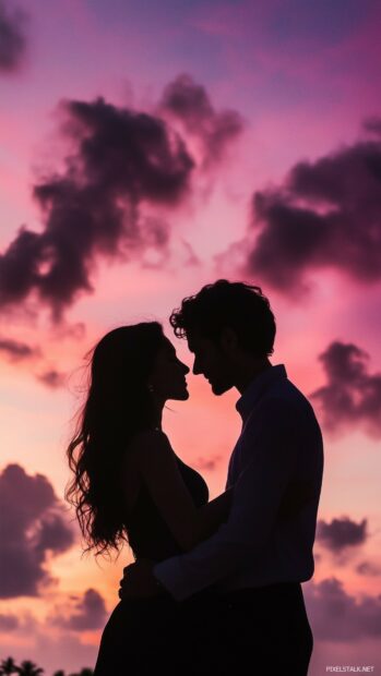 Love Wallpaper HD for iPhone with a silhouette of a couple embracing under a pink and purple sky filled with clouds, evoking feelings of deep love and connection.